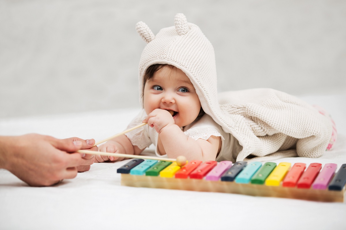 Малышка играет с музыкальной игрушкой