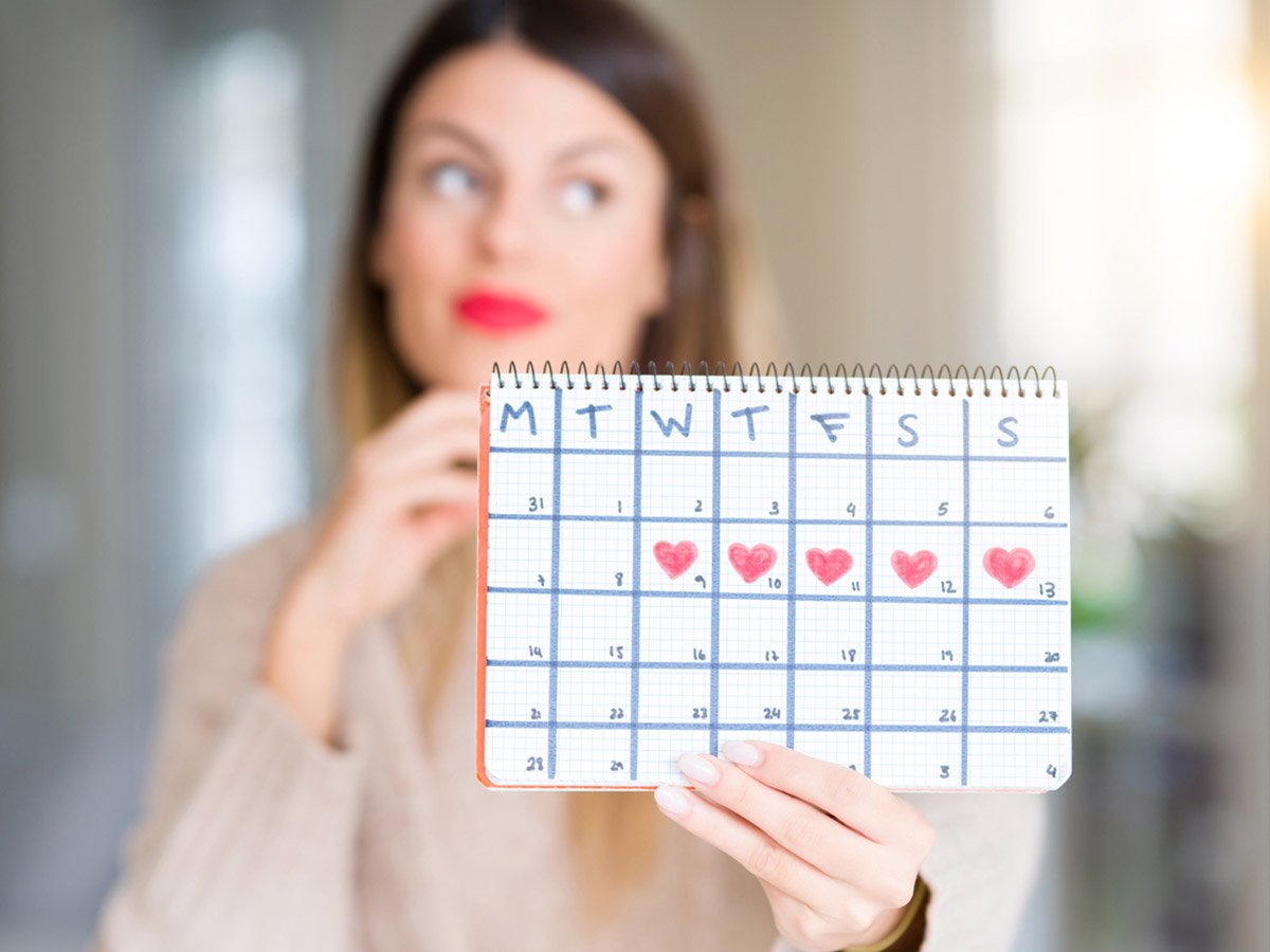 Перед месячными можно заниматься. Фотосессия менструационного цикла. Держит календарь. Календарь женщины для зачатия. Девушка и календарь Сток.