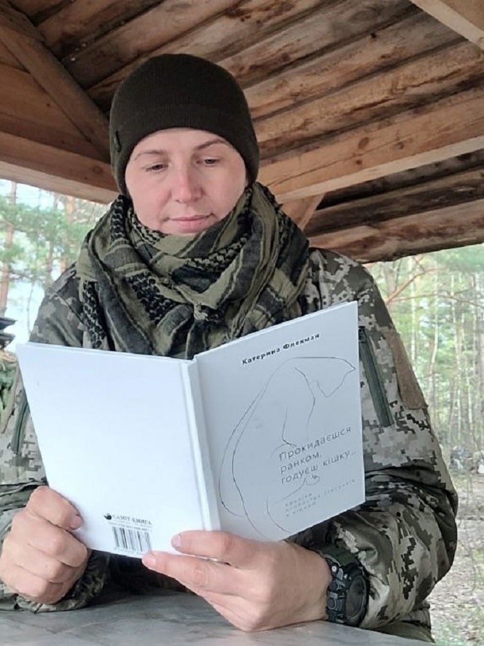 Жінка-військова Олена Риж читає книгу